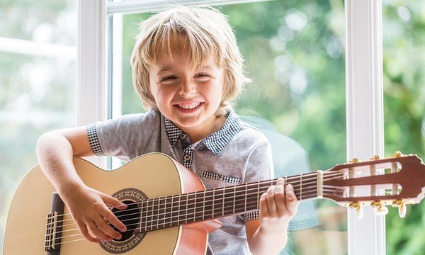 clases de guitarra para niños, modulo de guitarra para principiantes, niño tocando guitarra, clases de guitarra acustica y guitarra electrica